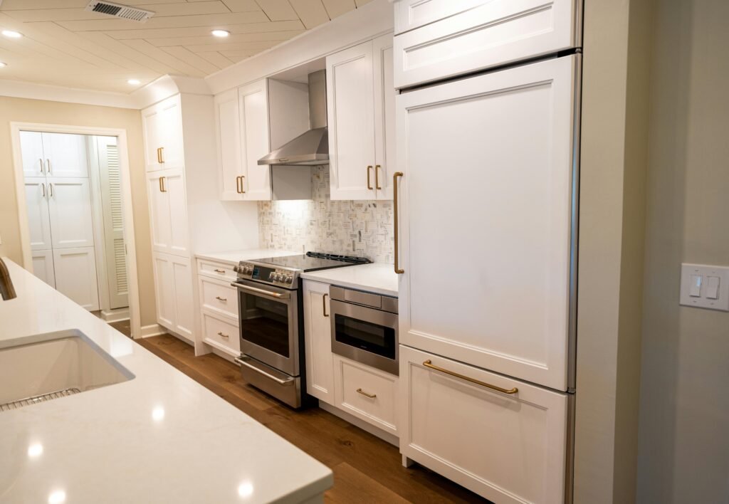 Elegant modern kitchen featuring white cabinetry and stainless steel appliances.